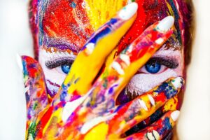 rosto de uma mulher coberta por pintura desenvolvendo sua confiança criativa